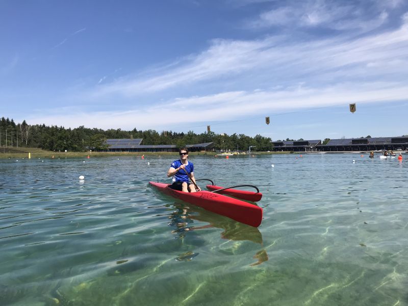 OC1-Paddler im roten Boot auf der Regattastrecke